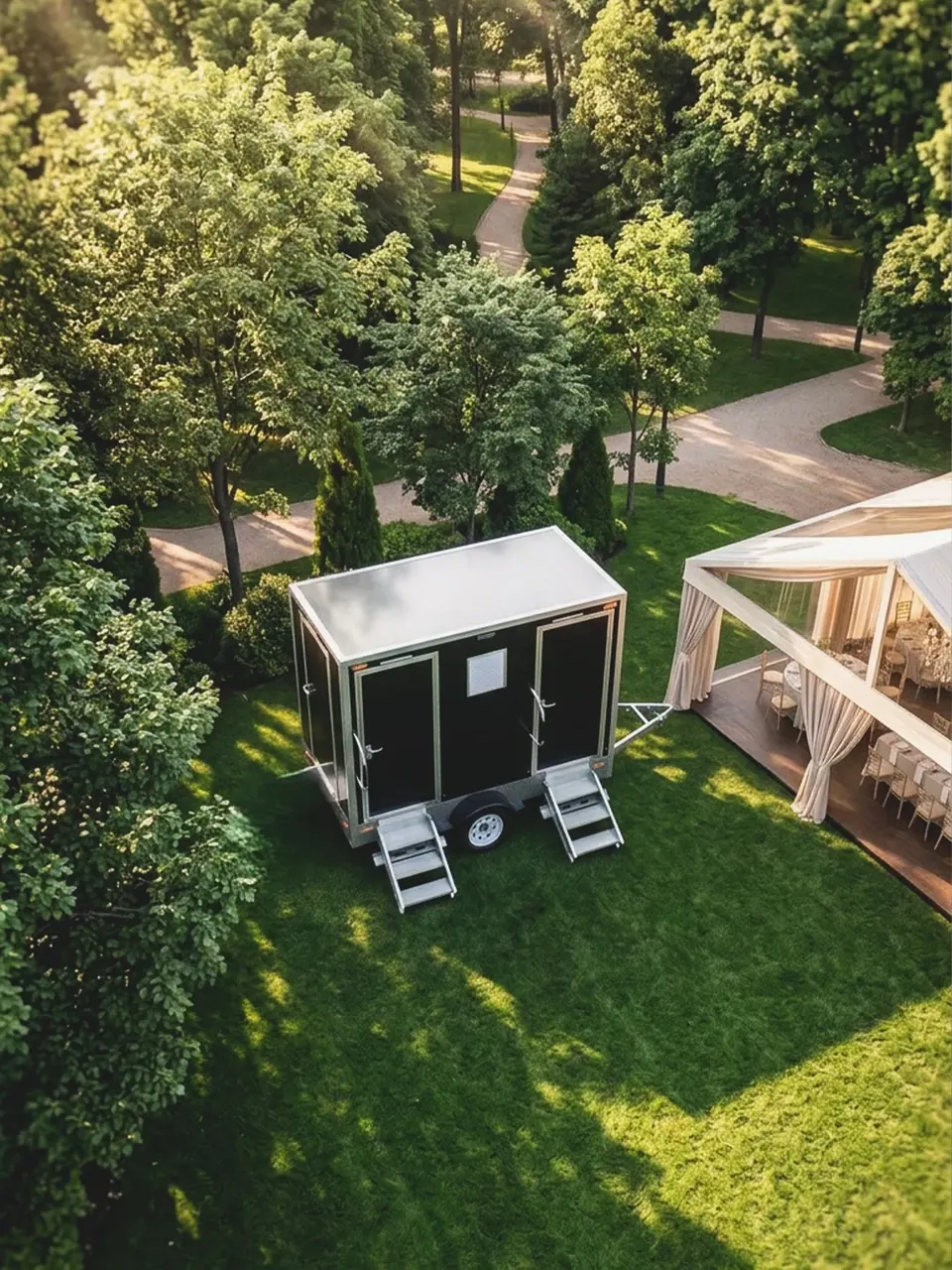 Restroom trailer positioned beside a landscaped outdoor gathering area